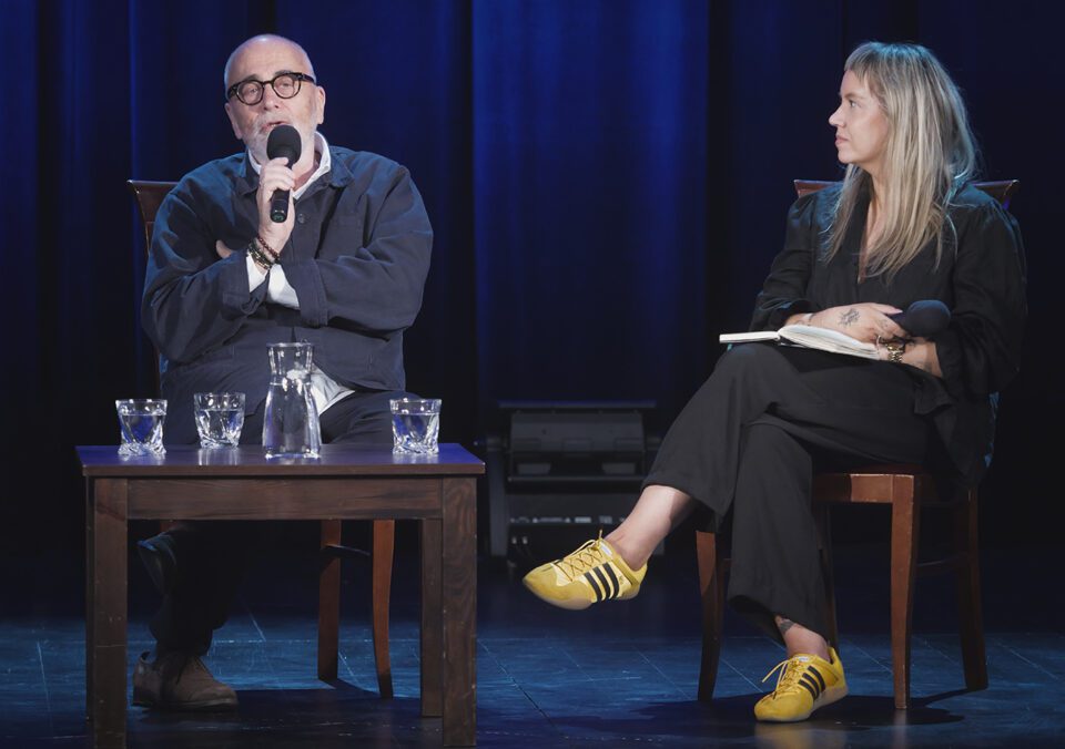 Kwieciński podczas rozmowy, obok niego, po prawej Chitro, która przygląda się rozmówcy.