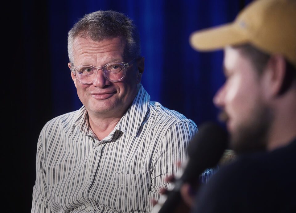Portret Mellera; mężczyzna pogodnie się uśmiecha.