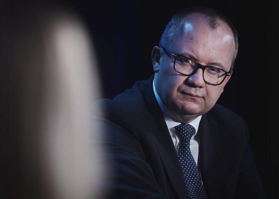 Portret Ministra Sprawiedliwości, prof. Bodnara; mężczyzna z pogodną miną słucha rozmówców, którzy są poza kadrem.