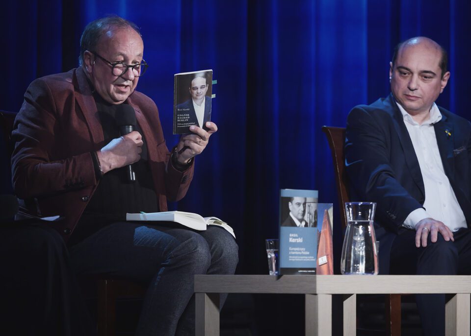 Prof. Traba i Emil Kerski podczas rozmowy; profesor trzyma w dłoni książkę Kerskiego pod tytułem "Gdańsk, Bagdad, Berlin".