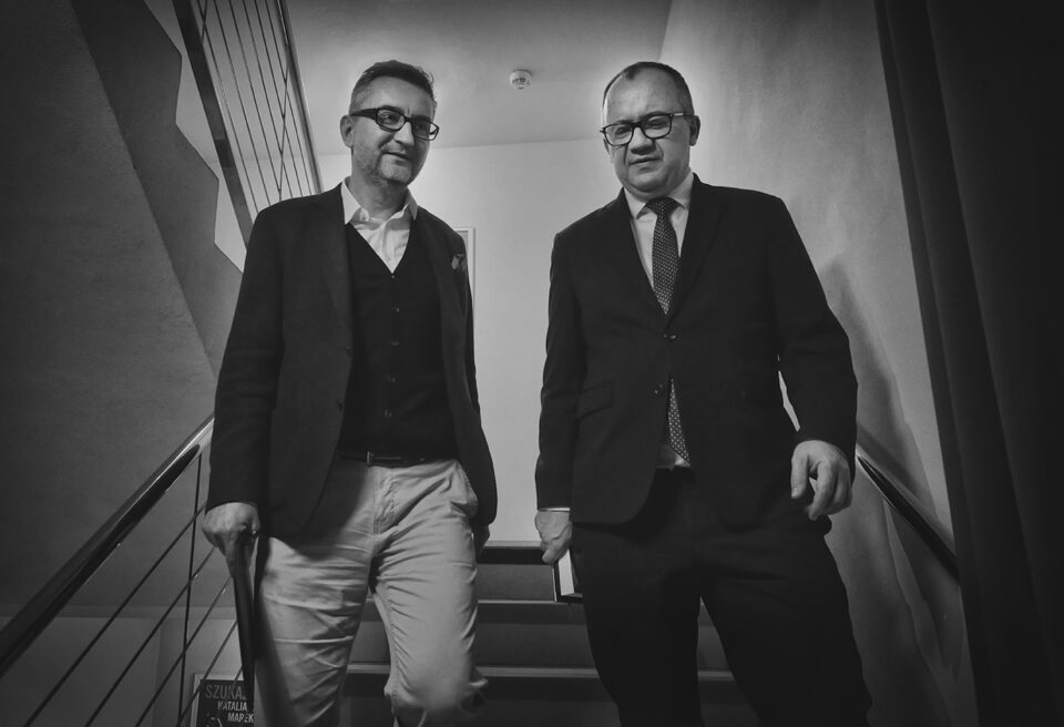 Czarno-białe zdjęcie; Dyrektor Teatru Starego i prof. Adam Bodnar podczas rozmowy; mężczyźni schodzą po schodach w teatrze.